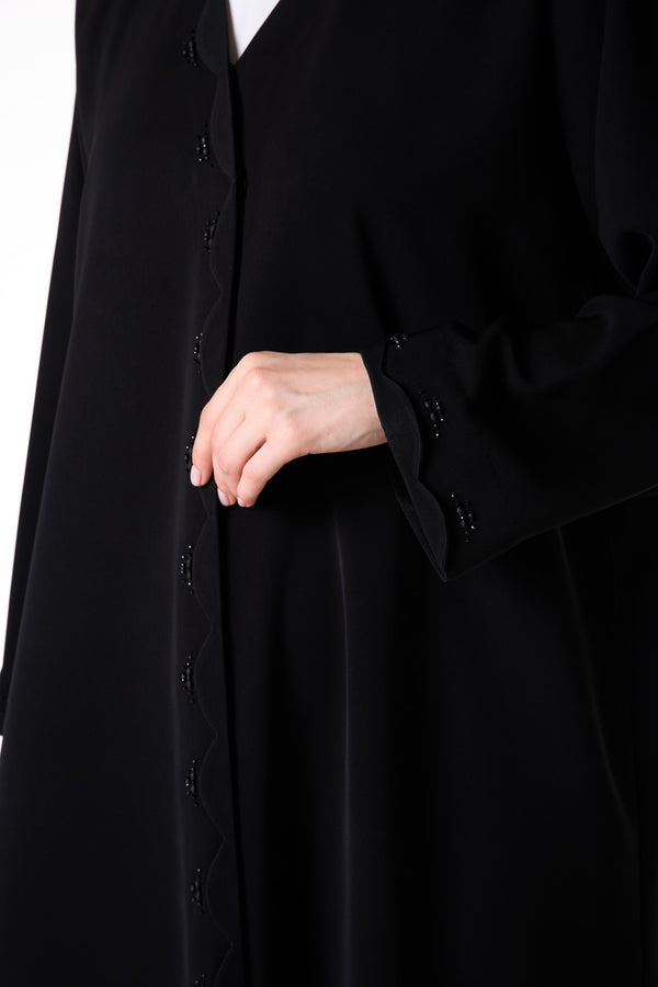 عباية ريا كريب سوداء بتفاصيل خرز على أطراف متموجة